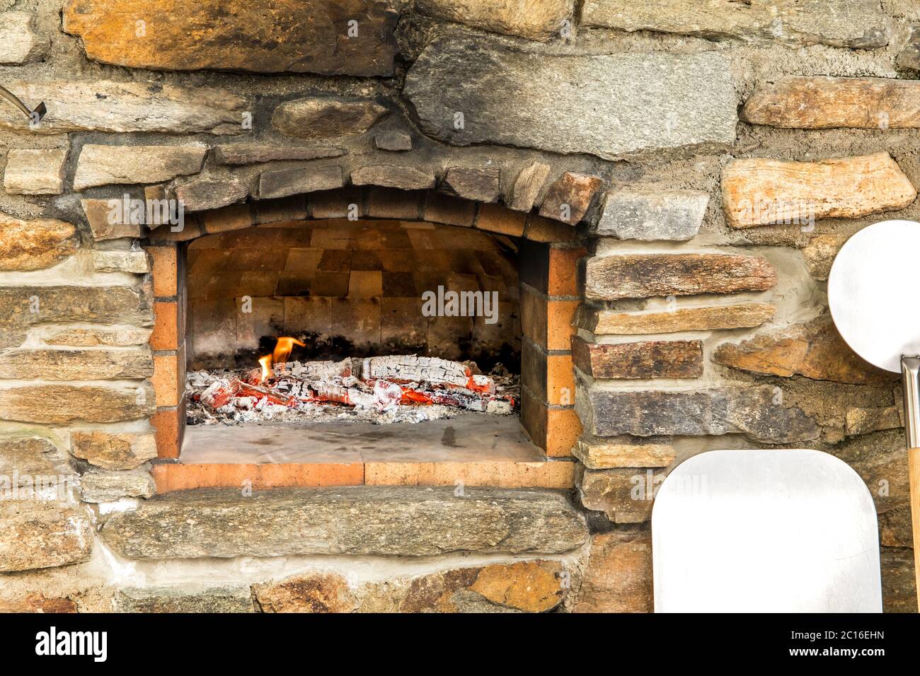 Old stone homemade pizza oven. Fire in the furnace. Homemade baking pizza.  Bakery. Traditional Italian food Stock Photo - Alamy