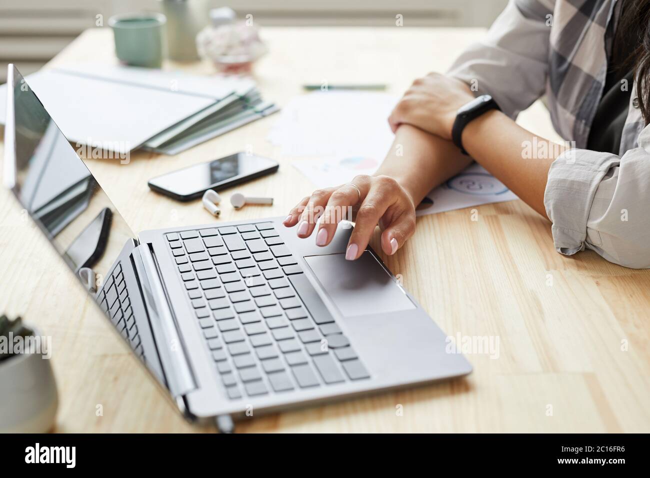 Close up of young mixed-race woman using laptop while working at home office, hands typing on keyboard, copy space Stock Photo