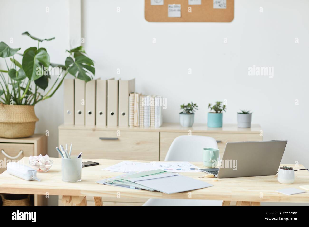 Minimal background image of clean home office interior with wooden desk and laptop, copy space Stock Photo