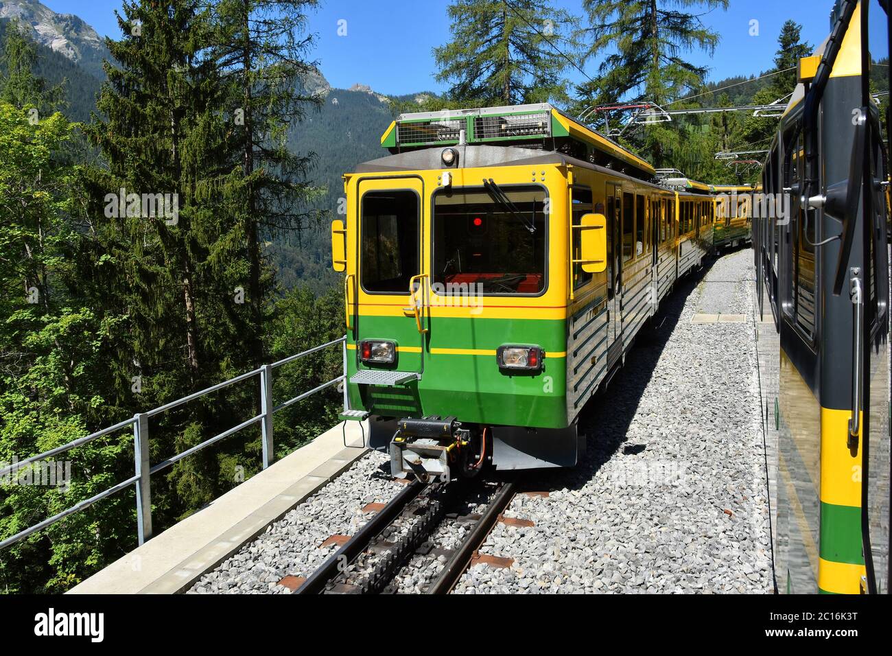 Yellow and green train - Bernese Highlands Railway, from Lauterbrunnen village to Grindelwald , Jungfrau region, Bernese Oberland, Switzerland Stock Photo
