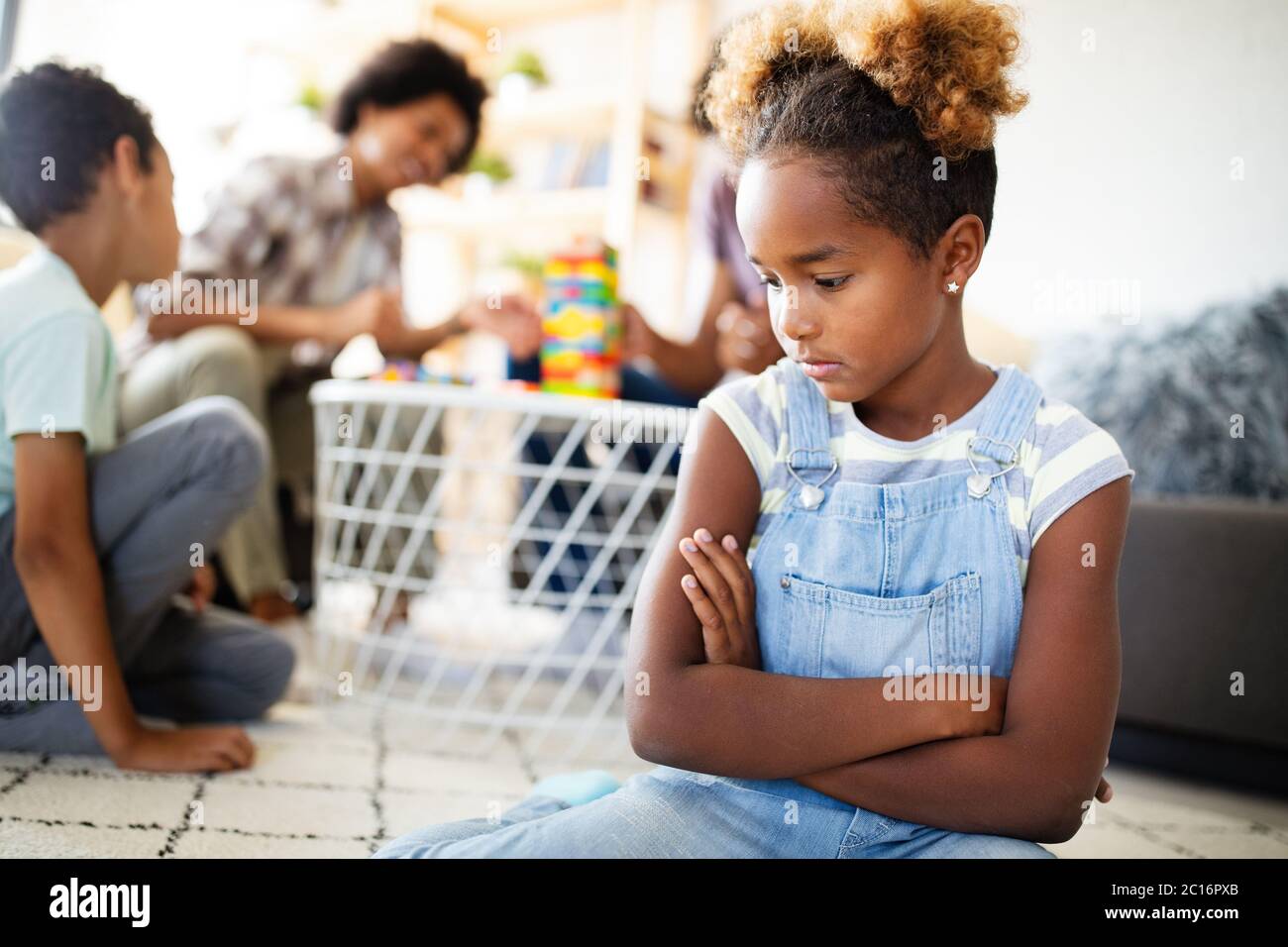 Little rebelious girl has conflict with family. Family problems. Social misbehaviour. Stock Photo