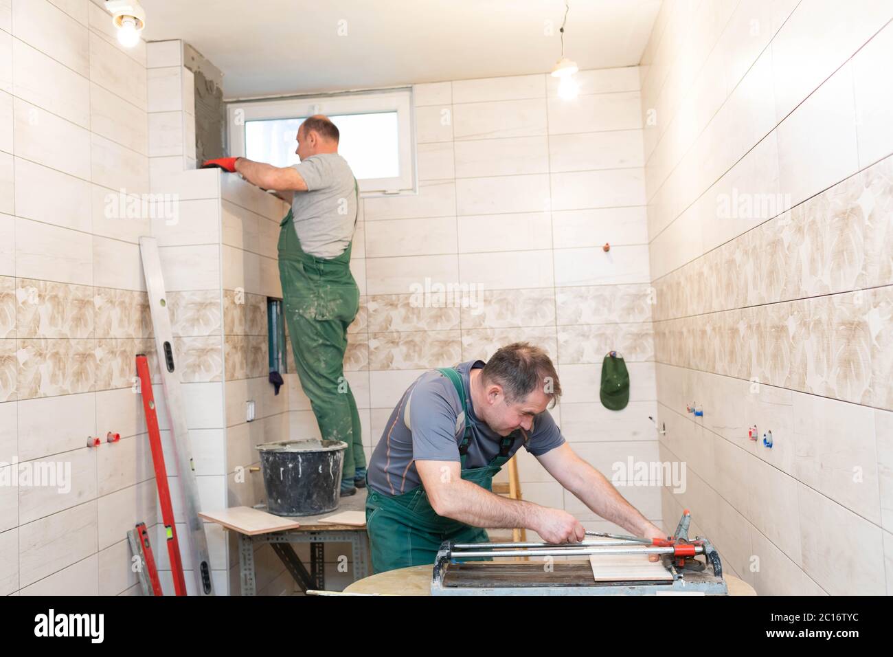 Tile cutting machine. Construction worker. Precise cutting of ceramic tiles. Stock Photo