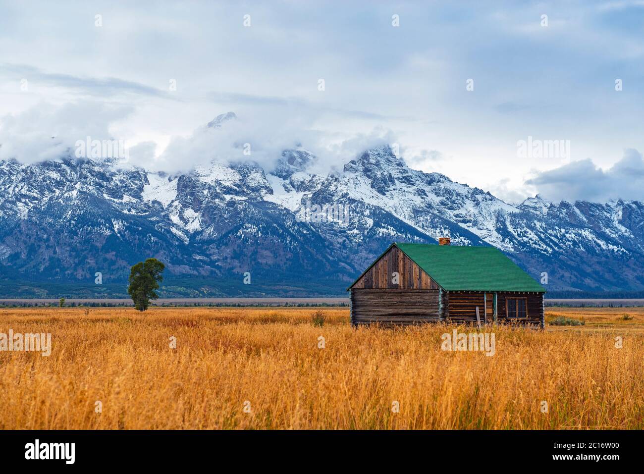 Grand Teton Range Peaks in the first snow and mist in autumn with a building of the T. A. Moulton barn inside Grand Teton National Park, Wyoming, USA. Stock Photo