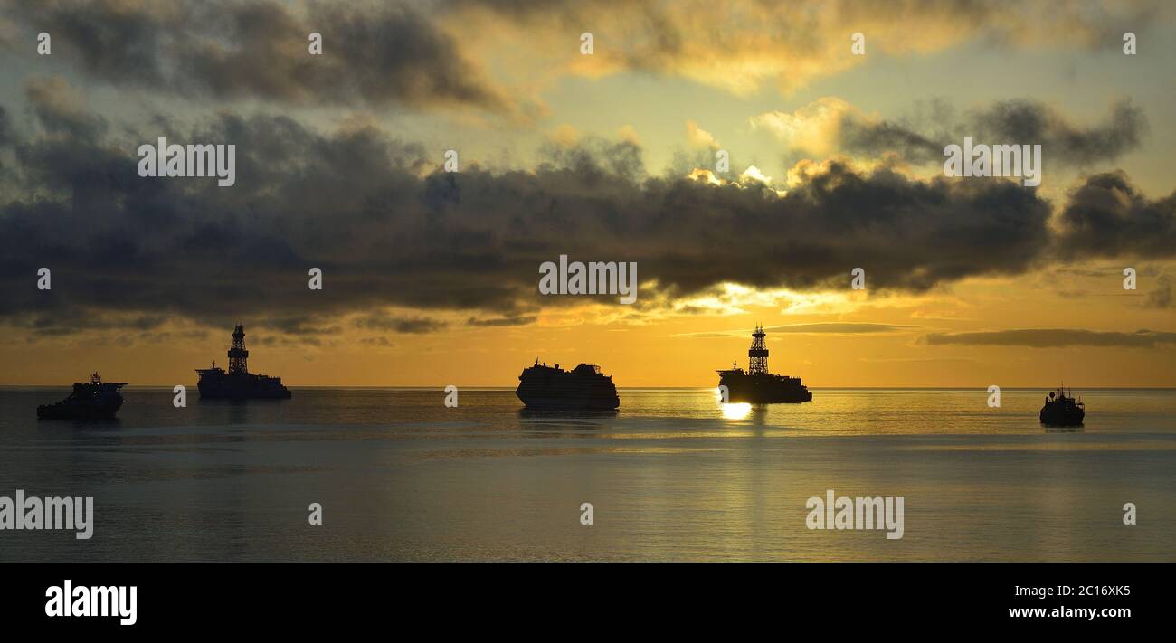 Ships anchored in the bay at sunrise, cloudy sky and calm sea Stock ...