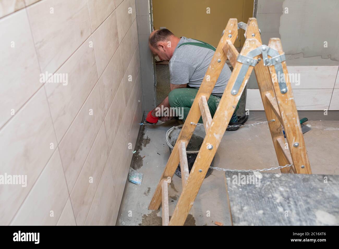 worker applying tile adhesive glue on the floor Stock Photo - Alamy