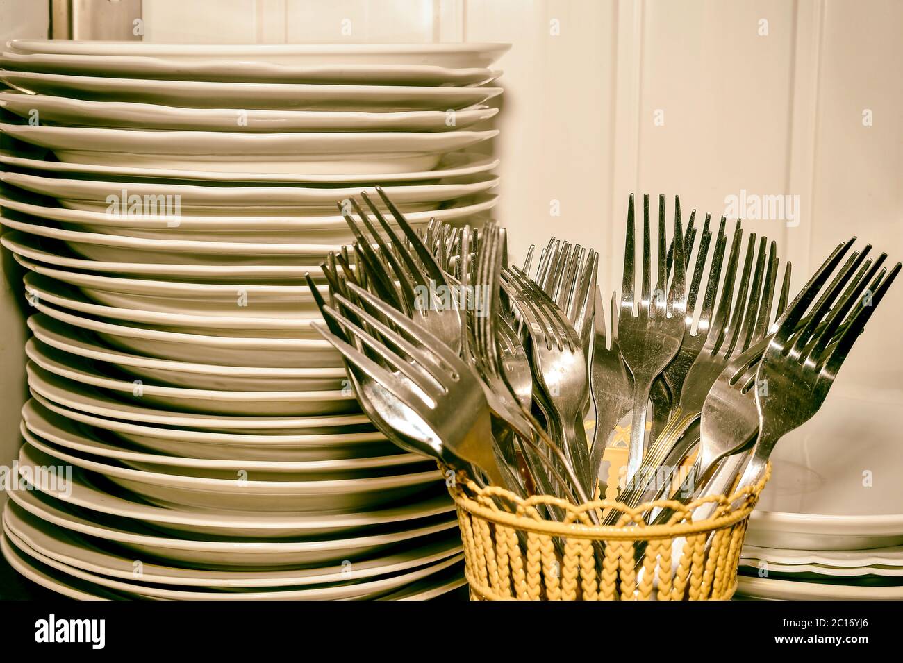 A stack of washed dishes and forks in the kitchen Stock Photo