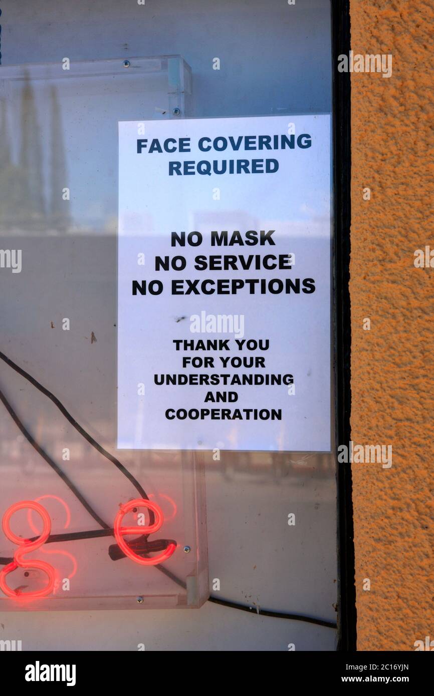 Sign in a bar window - Face covering Required. No Mask No Service, No Exceptions Stock Photo