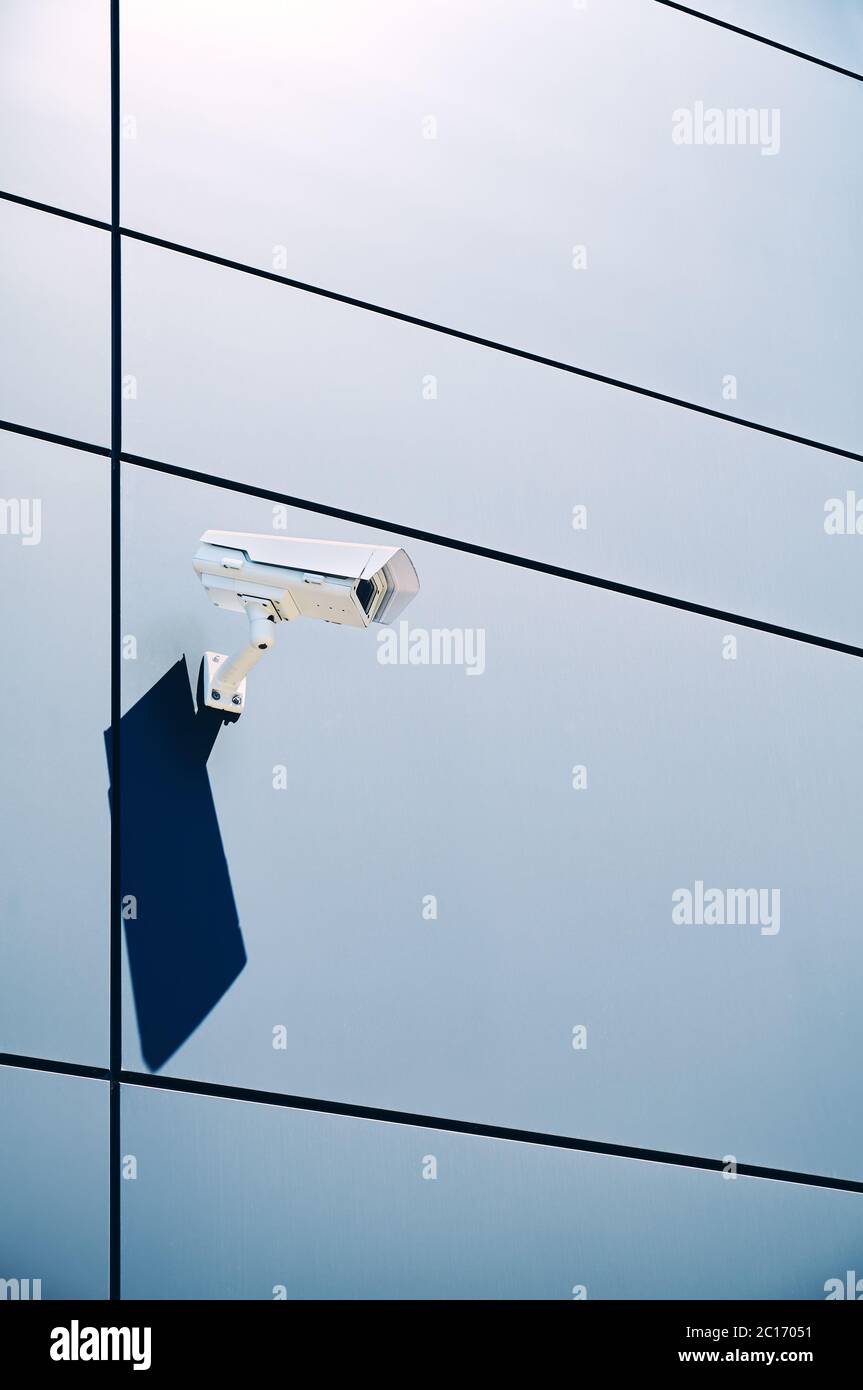 CCTV camera on an office building wall. Stock Photo