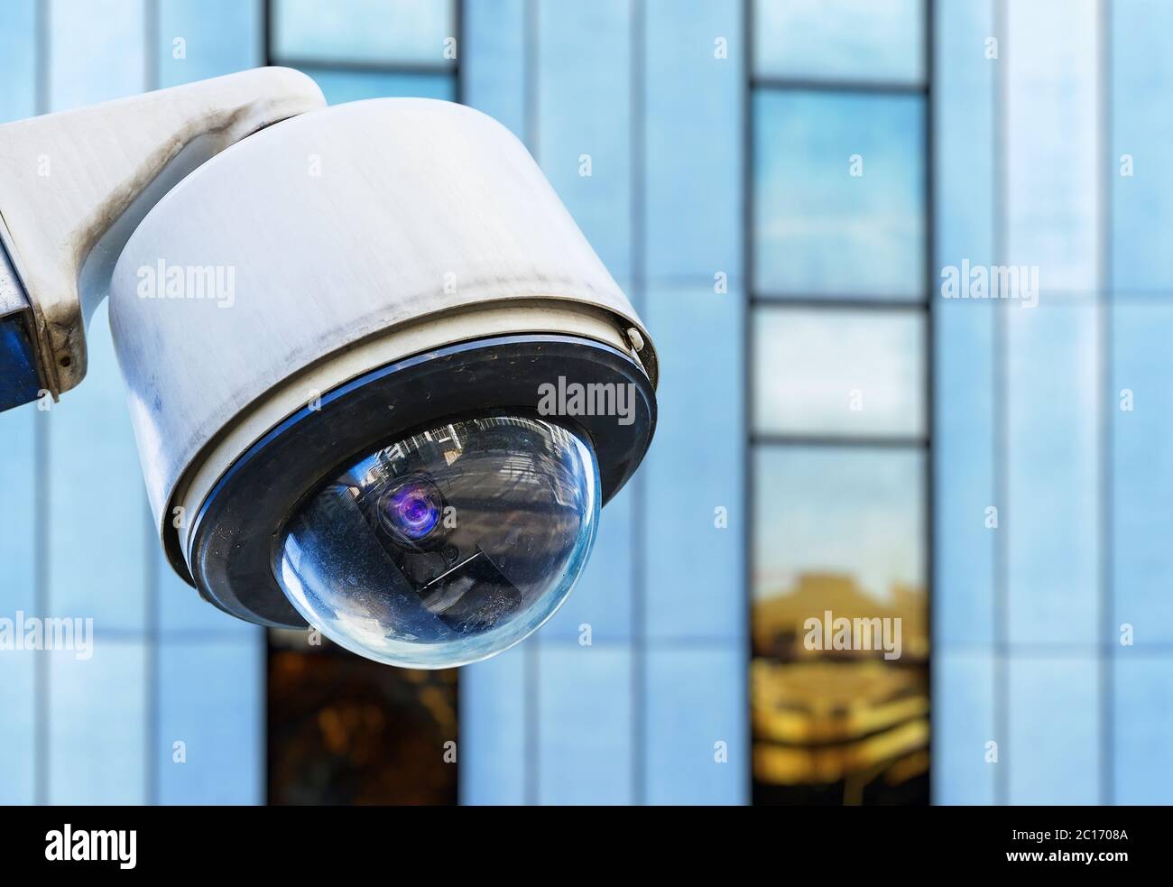 cctv security camera in a city with blury business building on background Stock Photo