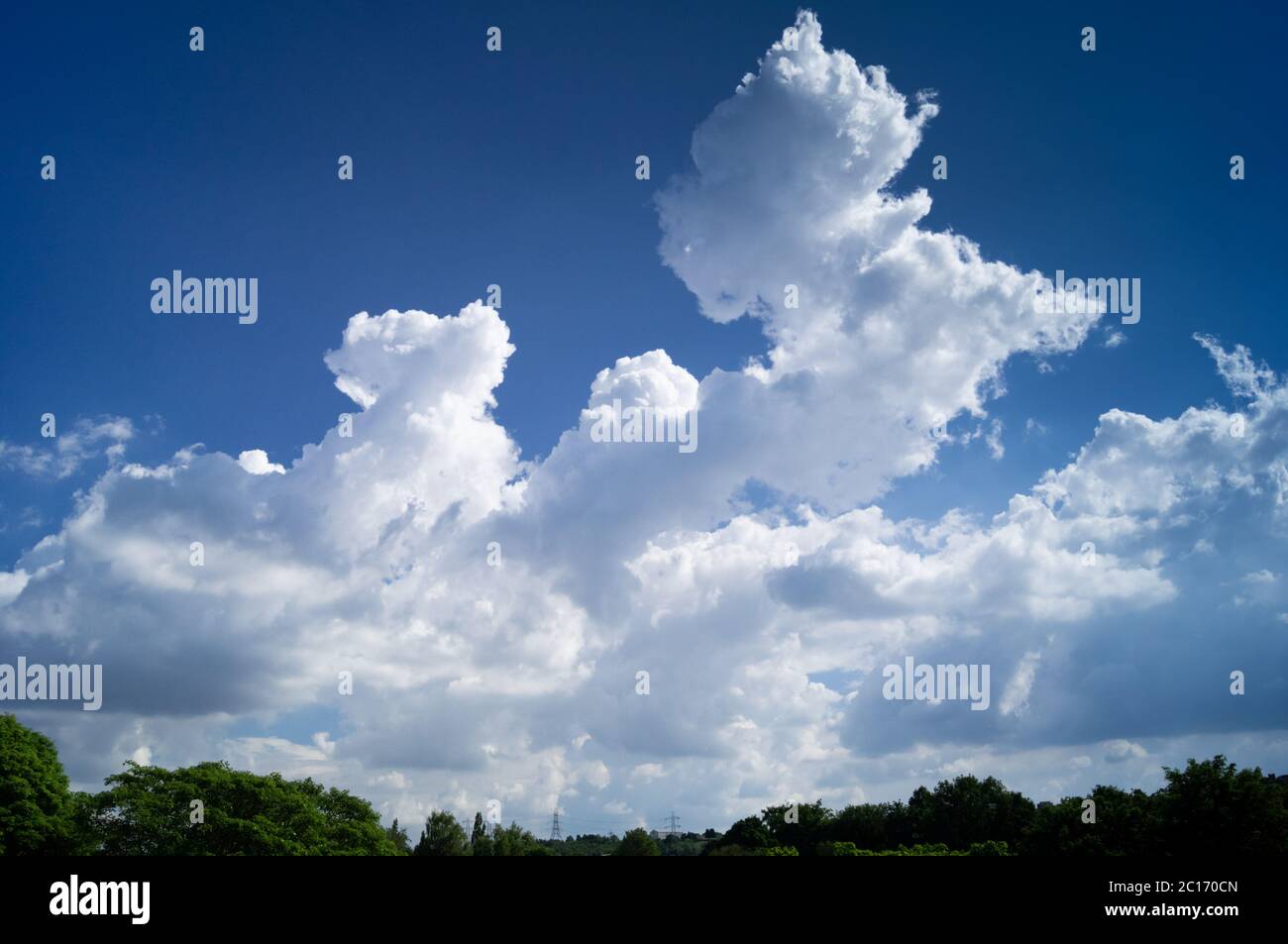 Deep blue sky with puffy clouds prior to a storm building, storm brewing, calm before storm, cumulus, cumulonimbus Stock Photo
