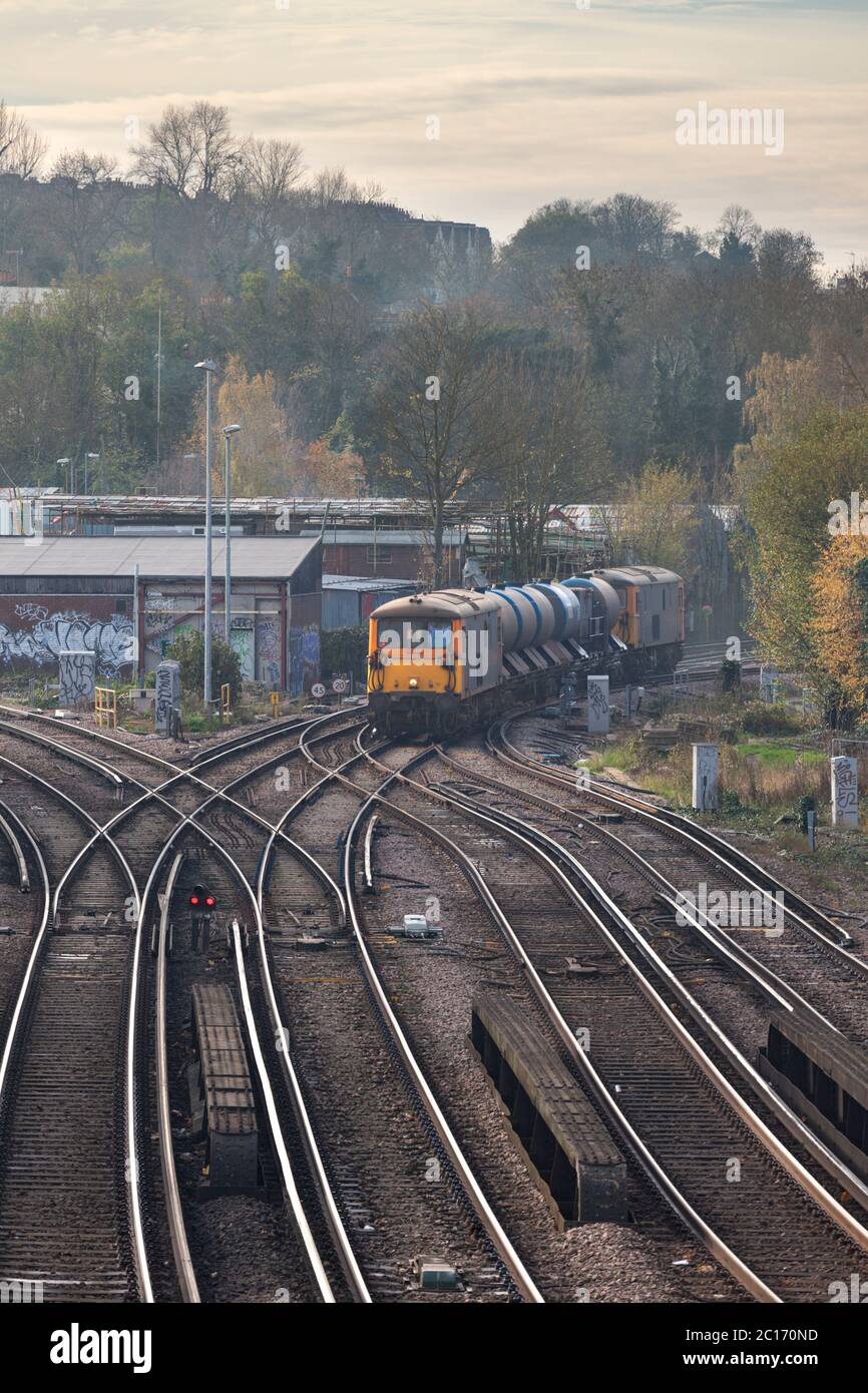 GB Railfreight class 73 dual mode locomotive line with a Network Rail railhead treatment train jetting autumn leaves from the line Stock Photo