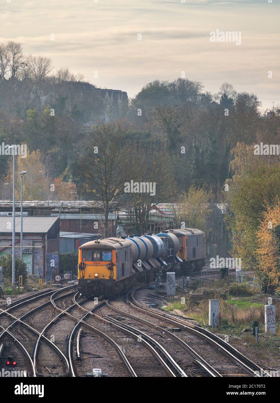 GB Railfreight class 73 dual mode locomotive line with a Network Rail railhead treatment train jetting autumn leaves from the line Stock Photo