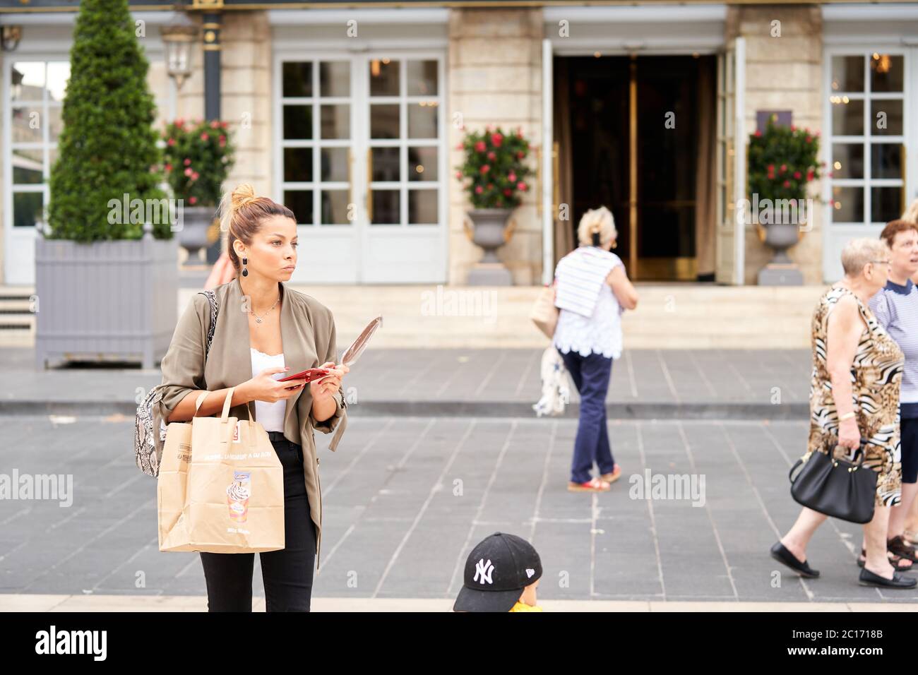 A woman waits for her car outside the luxury Intercontinental Grand Hotel de Bordeaux in Place de la Comedie in the centre of Bordeaux city Stock Photo