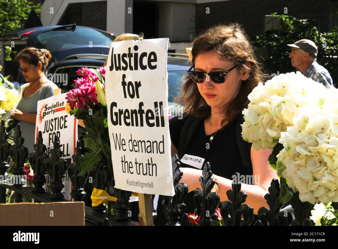 London, UK. 17th June, 2017. A volunteer tends to memorial flowers outside the Notting Hill Methodist Church during the aftermath.A fire caused by an electrical fault in a refrigerator, broke out in the 24-stored Grenfell Tower block of flats in North Kensington, West London where 72 people died, more than 70 others were injured and 223 people escaped. Credit: David Mbiyu/SOPA Images/ZUMA Wire/Alamy Live News Stock Photo