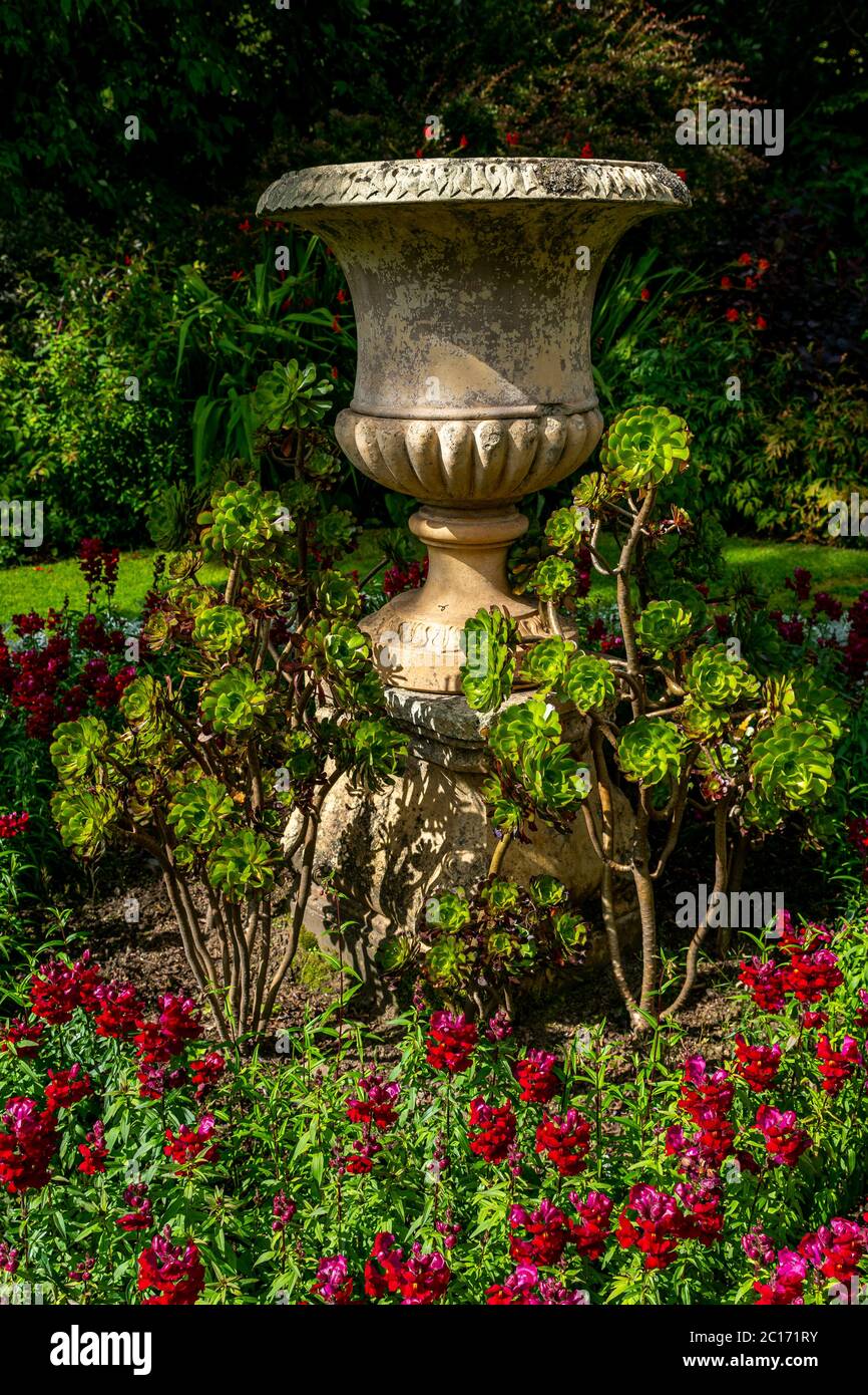 Garden urn surrounded by flowers. Stock Photo