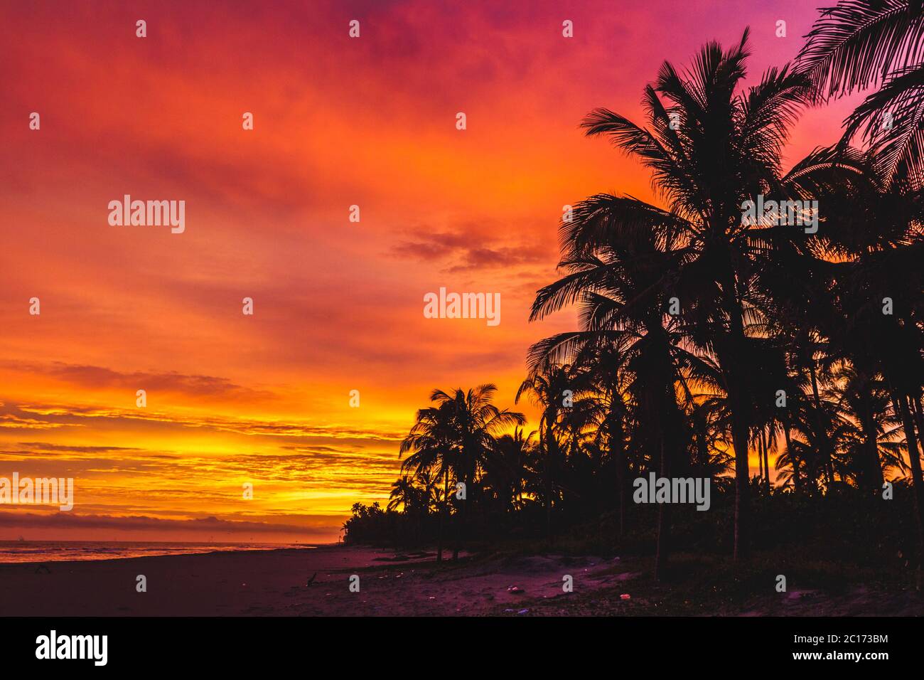 Orange and pink sky sunset on a beach - Stock Image