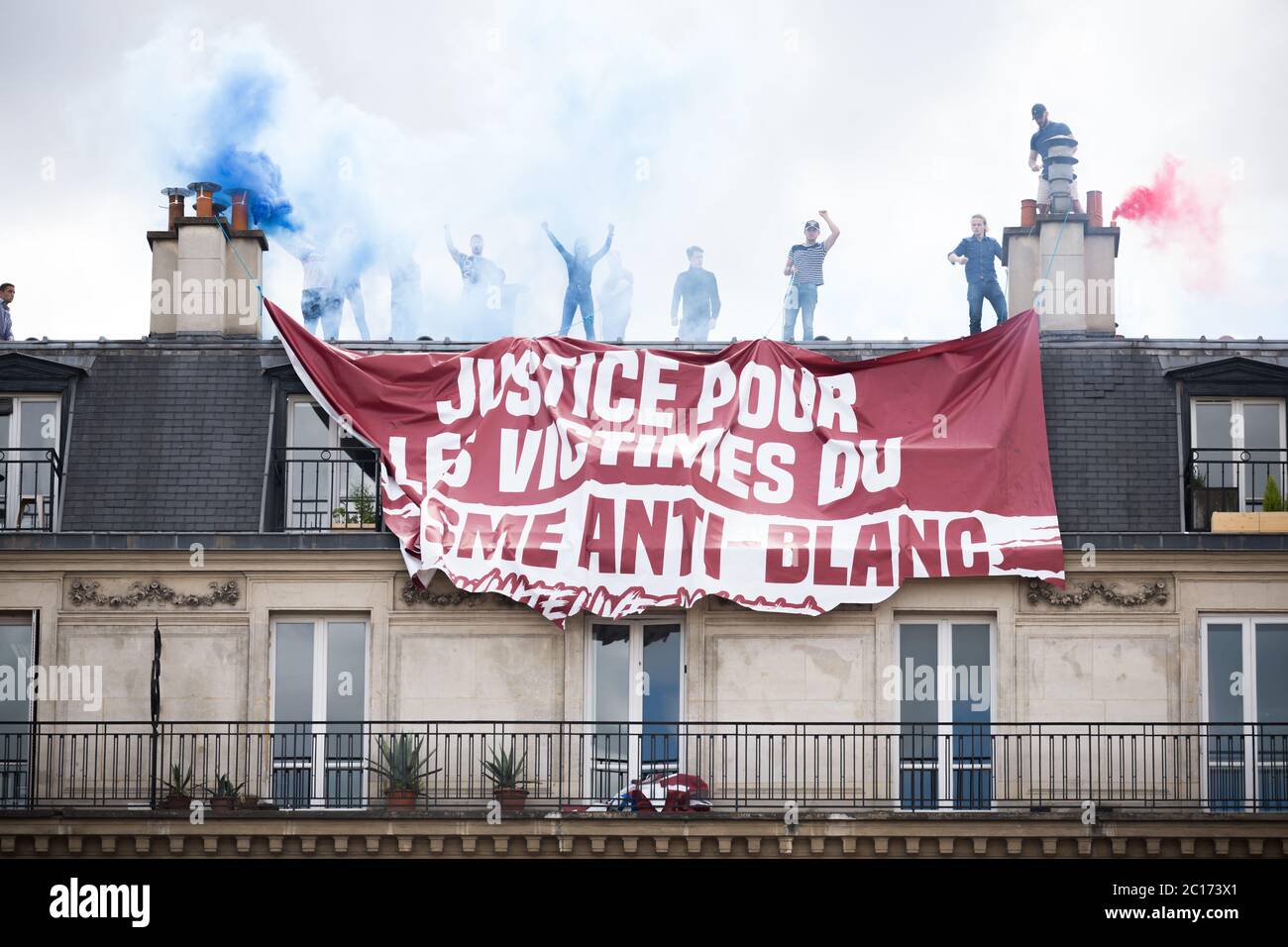 Paris, France. 13th June, 2020. Members of a right wing group that hung a banner in support of victims of anti-white racism cheer and light flares on top of a building at Place de la Republique during a Black Lives Matter protest in paris, France, on June 13th, 2020. (Photo by Daniel Brown/Sipa USA) Credit: Sipa USA/Alamy Live News Stock Photo