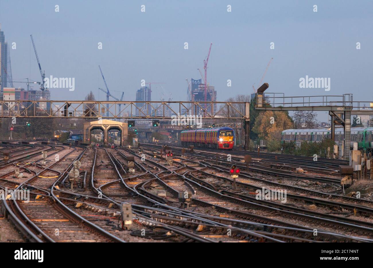 South West Trains class 456 inner suburban train passing Clapham Junction, south London with the tower cranes on the London skyline behind. Stock Photo