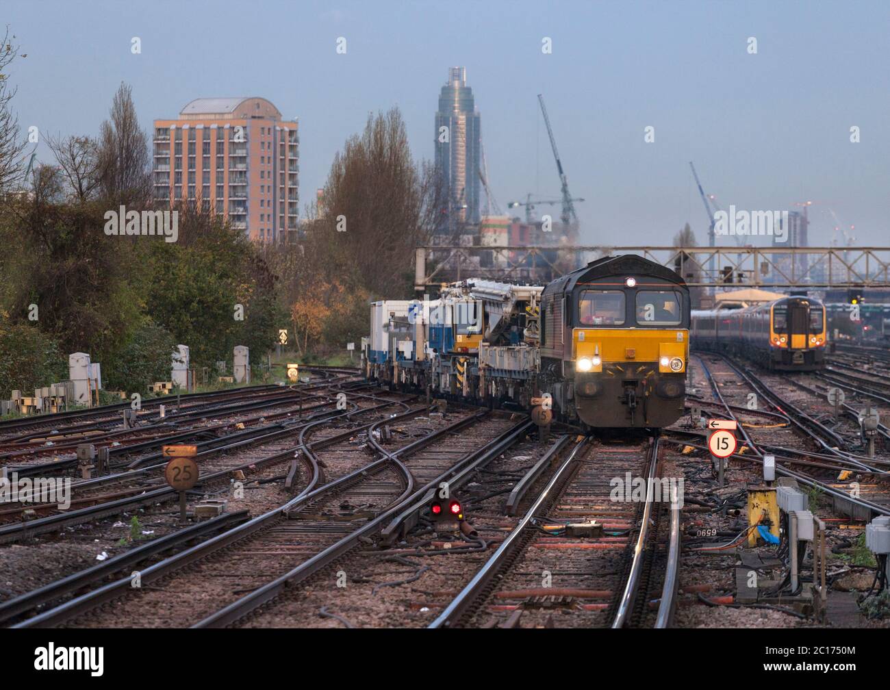 Colas Rail Freight class 66 locomotive 66850 crossing the junctions at Clapham junction with a Kirow rail crane being moved for Network Rail Stock Photo