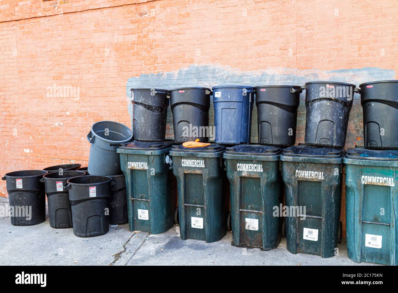 New Orleans Louisiana,Warehouse District,trash cans,bins,round container,commercial waste,brick wall,Rubbermaid,55 gallon Brute,plastic,rollout,heavy Stock Photo