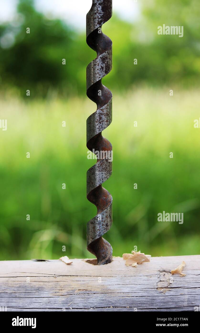 Metal spiral drill for making holes in logs when assembling a wooden