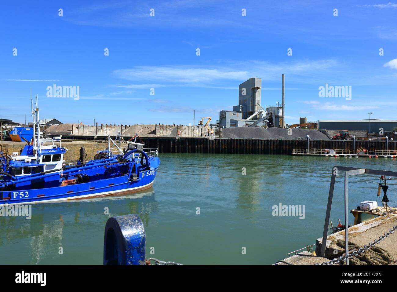 A view of the aggregates factory and the fishing boats in the Harbour at Whitstable Stock Photo