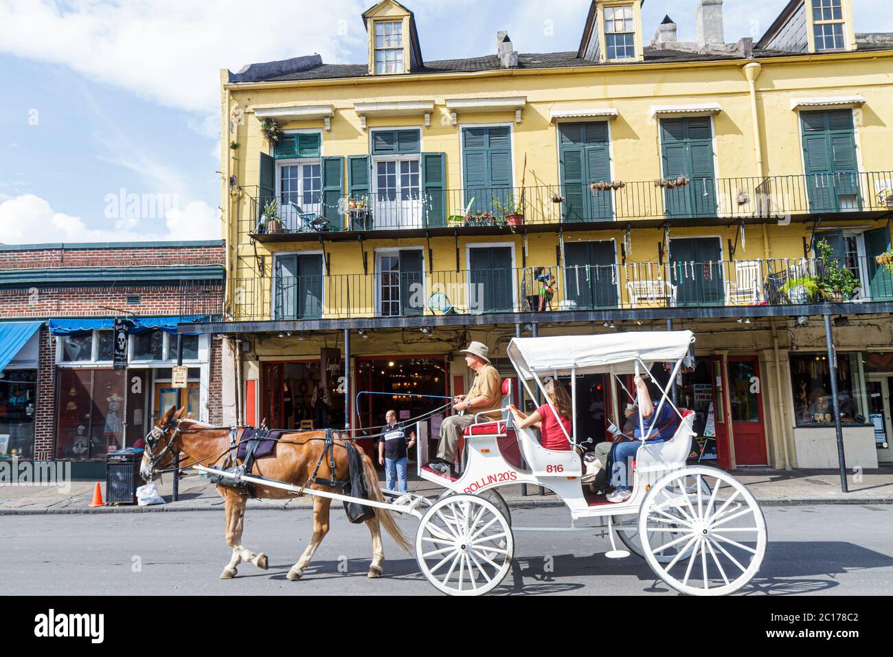 New Orleans Louisiana,French Quarter,907 Decatur,architecture heritage building,gallery,balcony,dormer window,man men male,woman female women,mule,car Stock Photo