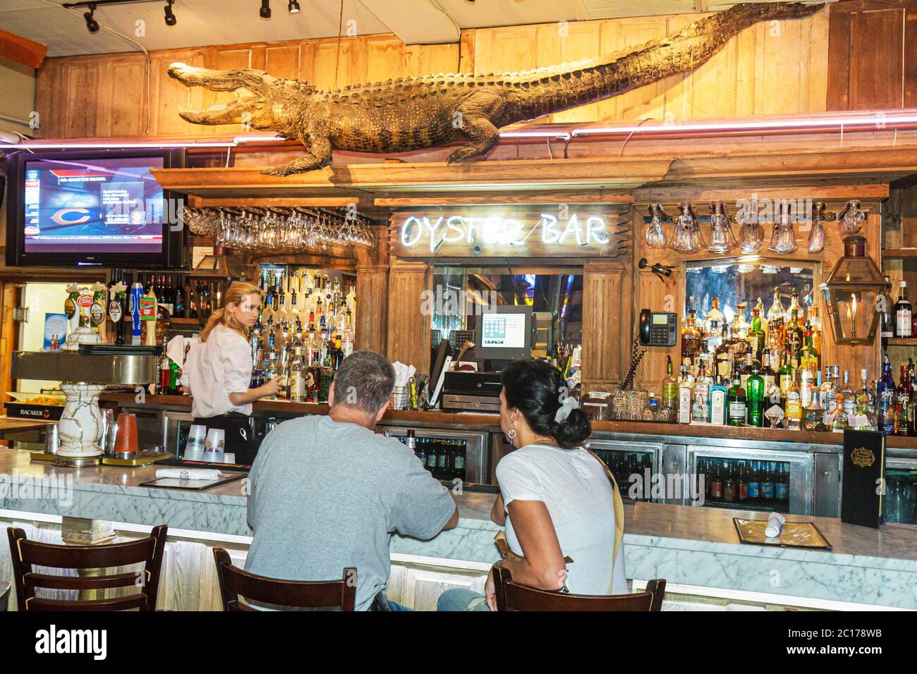 New Orleans Louisiana,French Quarter,Bourbon Street,Oyster Bar,drink drinks drinking,liquor,alcohol,bottles,glasses,bartender,man men male,woman femal Stock Photo