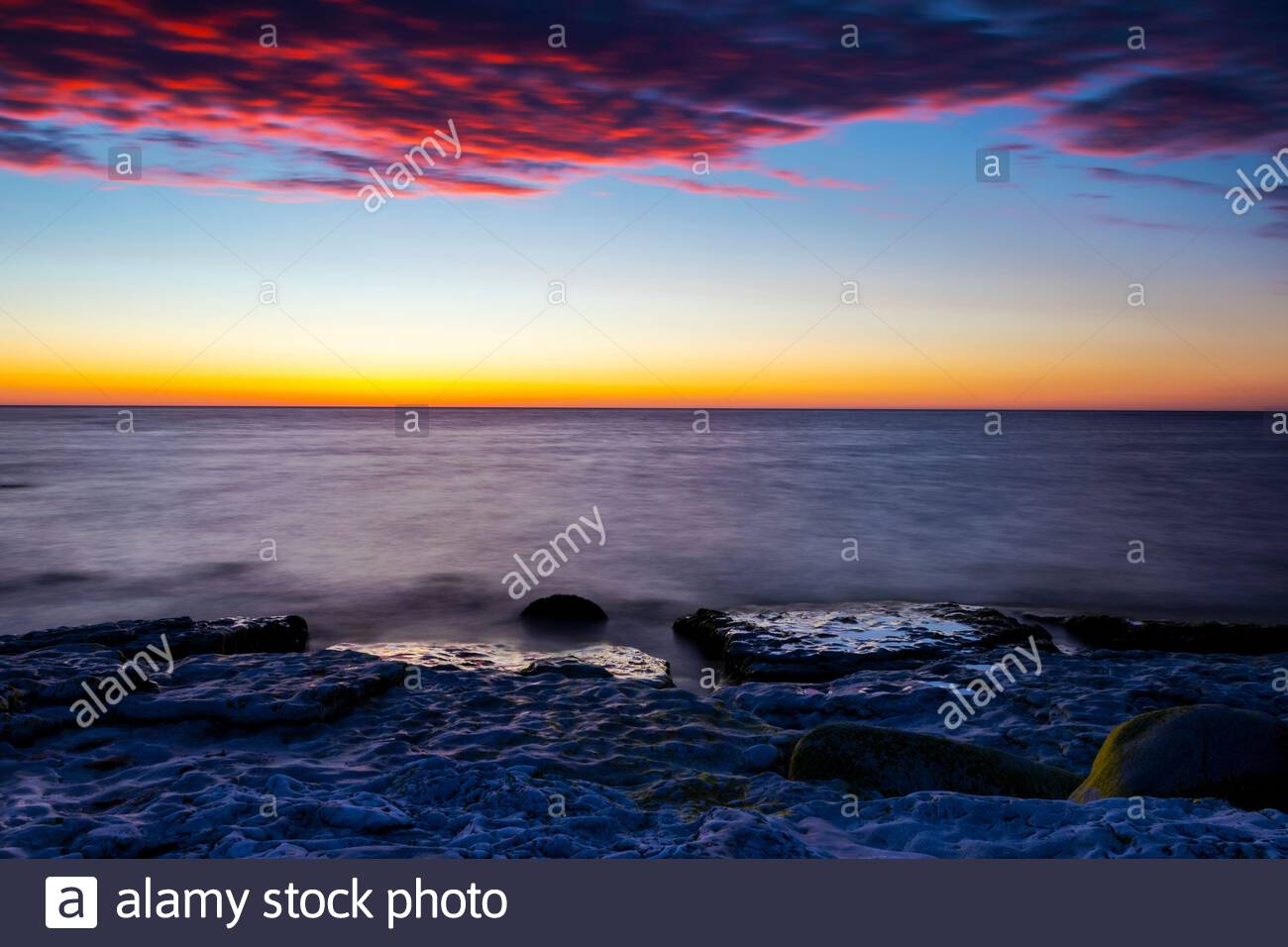 Cloudy Summer Sunset Reflecting In Ocean With Endless Horizon And Deep Blue Ocean Silhouette Of Boulders Laying In The Foreground In Shallow Water At Stock Photo Alamy Cloudy Summer Sunset Reflecting In Ocean With Endless Horizon And Deep Blue Ocean Silhouette Of Boulders Laying In The Foreground In Shallow Water At Stock Photo Alamy