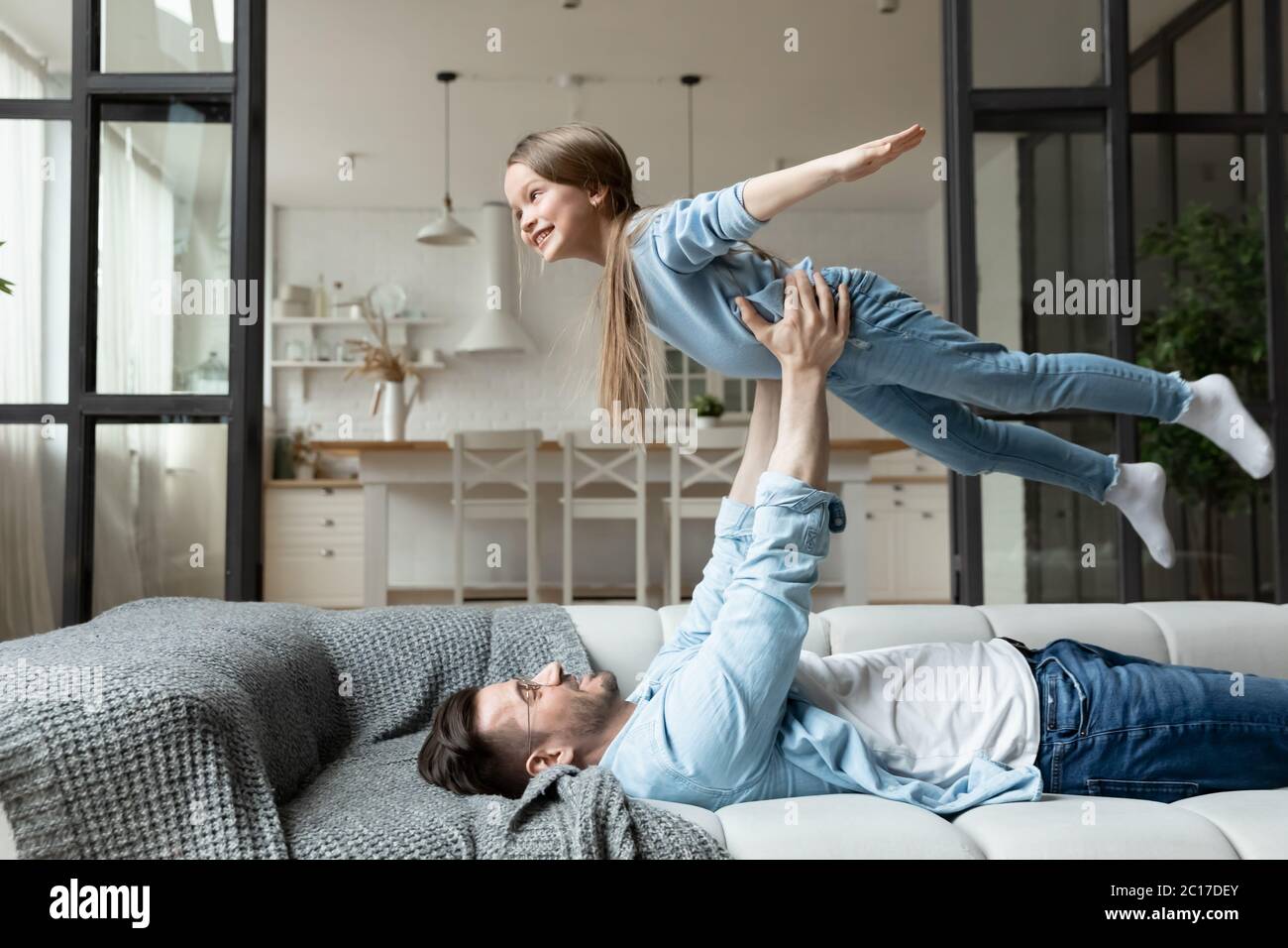 Little girl flying in air while daddy lifts up her Stock Photo - Alamy
