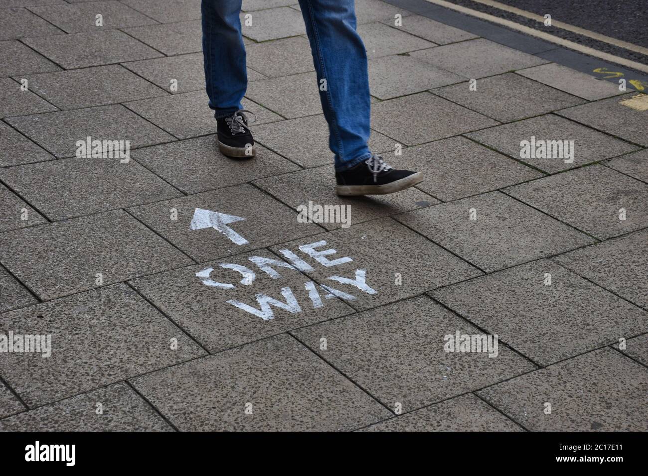 Oxford, UK- 06 13 2020: Oxford introduces social distancing to the city centre streets. Here a person walks past a pavement sign the wrong way. Stock Photo