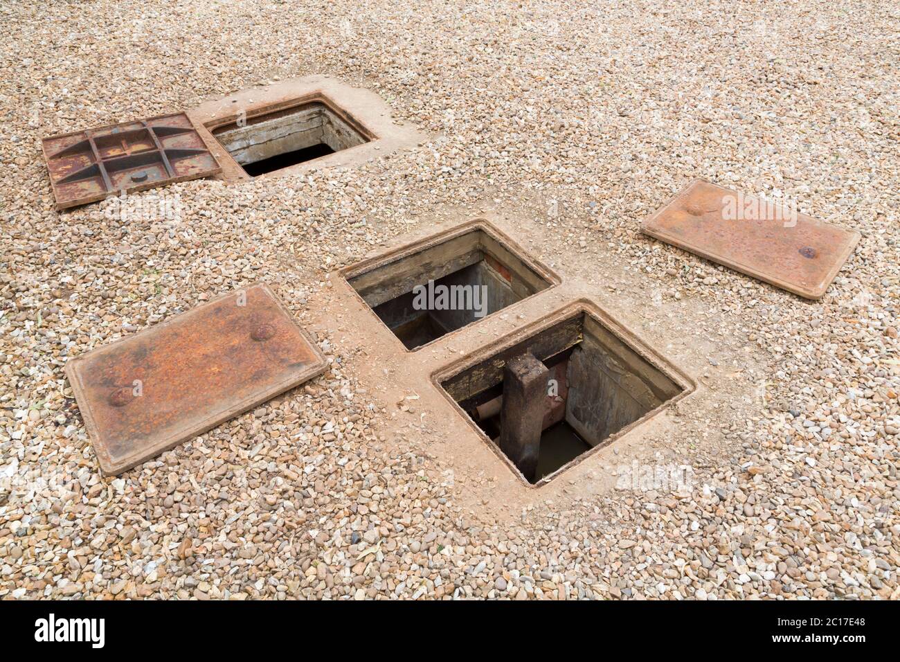 Inspecting an underground septic tank or rainwater system with open manhole cover, UK Stock Photo