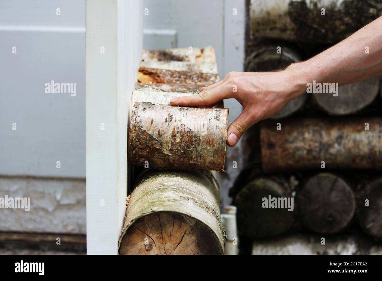 The worker restores a window in the historical building - a birch house of the Gatchina park, fastening pieces of birch with a s Stock Photo