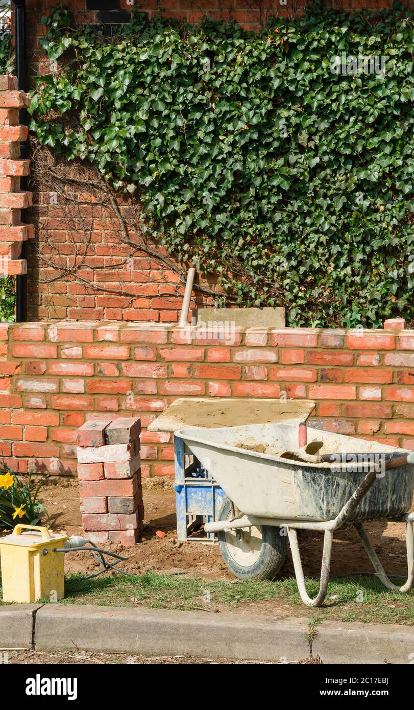 Brick laying, building a red brick garden wall in the UK Stock Photo