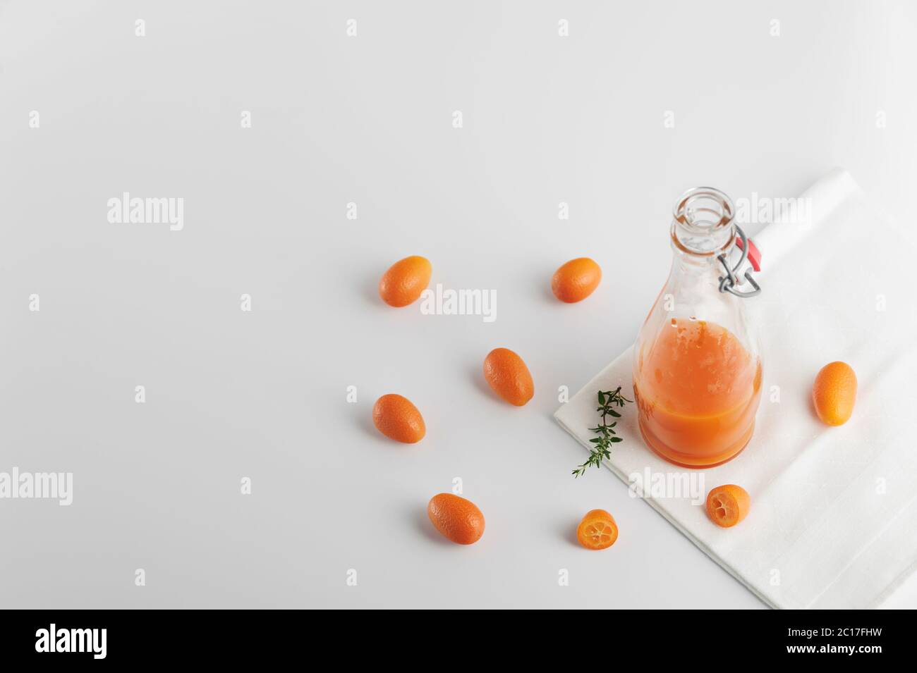 Healthy detox juice made with  tangerines  and kumquats in the glass bottle over white background.Horizontal orientation with space for text. Stock Photo