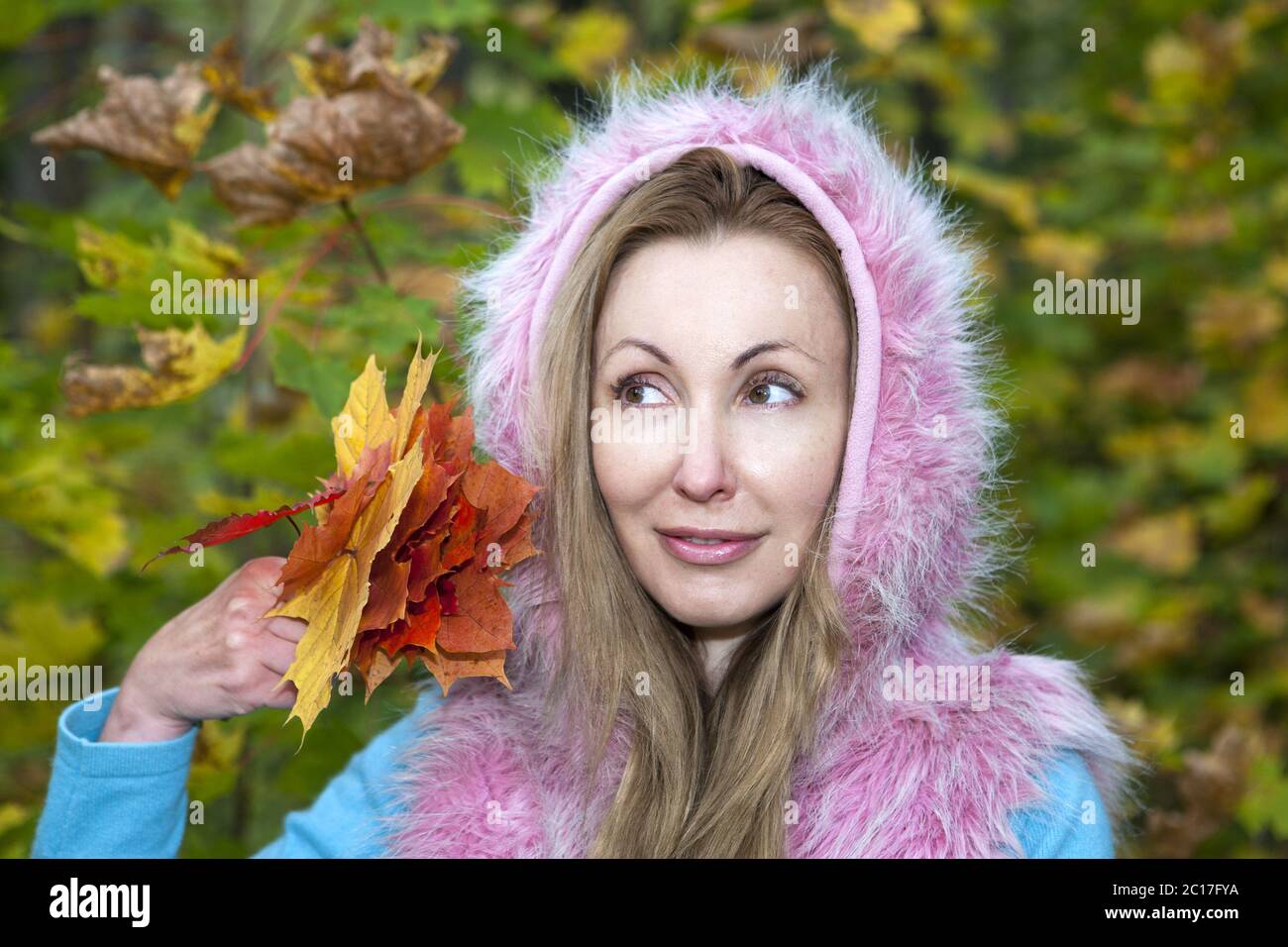 The beautiful woman in autumn park with maple leaves Stock Photo - Alamy