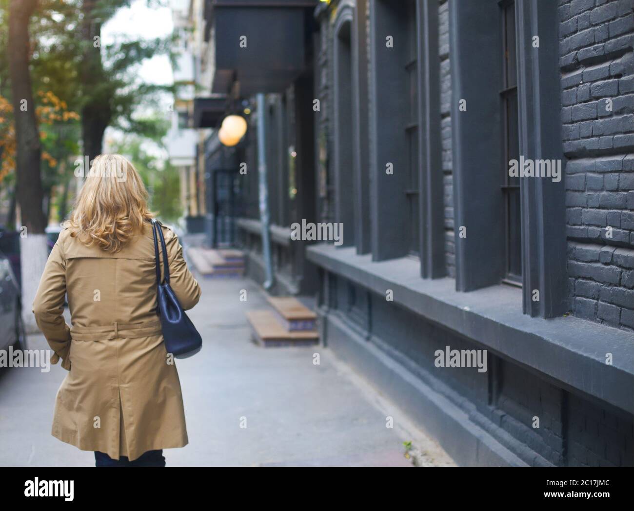Middle age women goes through the city and smiles. Loneliness concept. Stock Photo