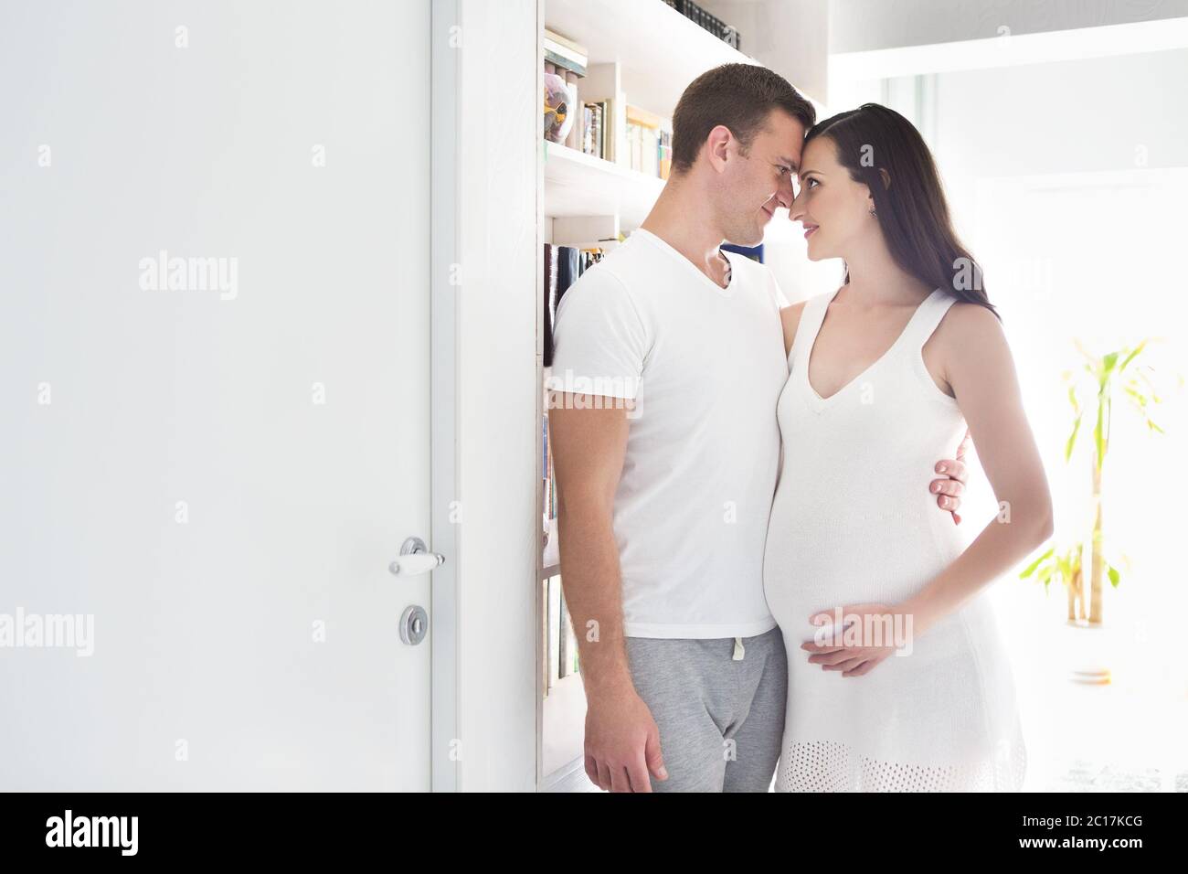 Young man and pretty pregnant woman hugging together Stock Photo - Alamy