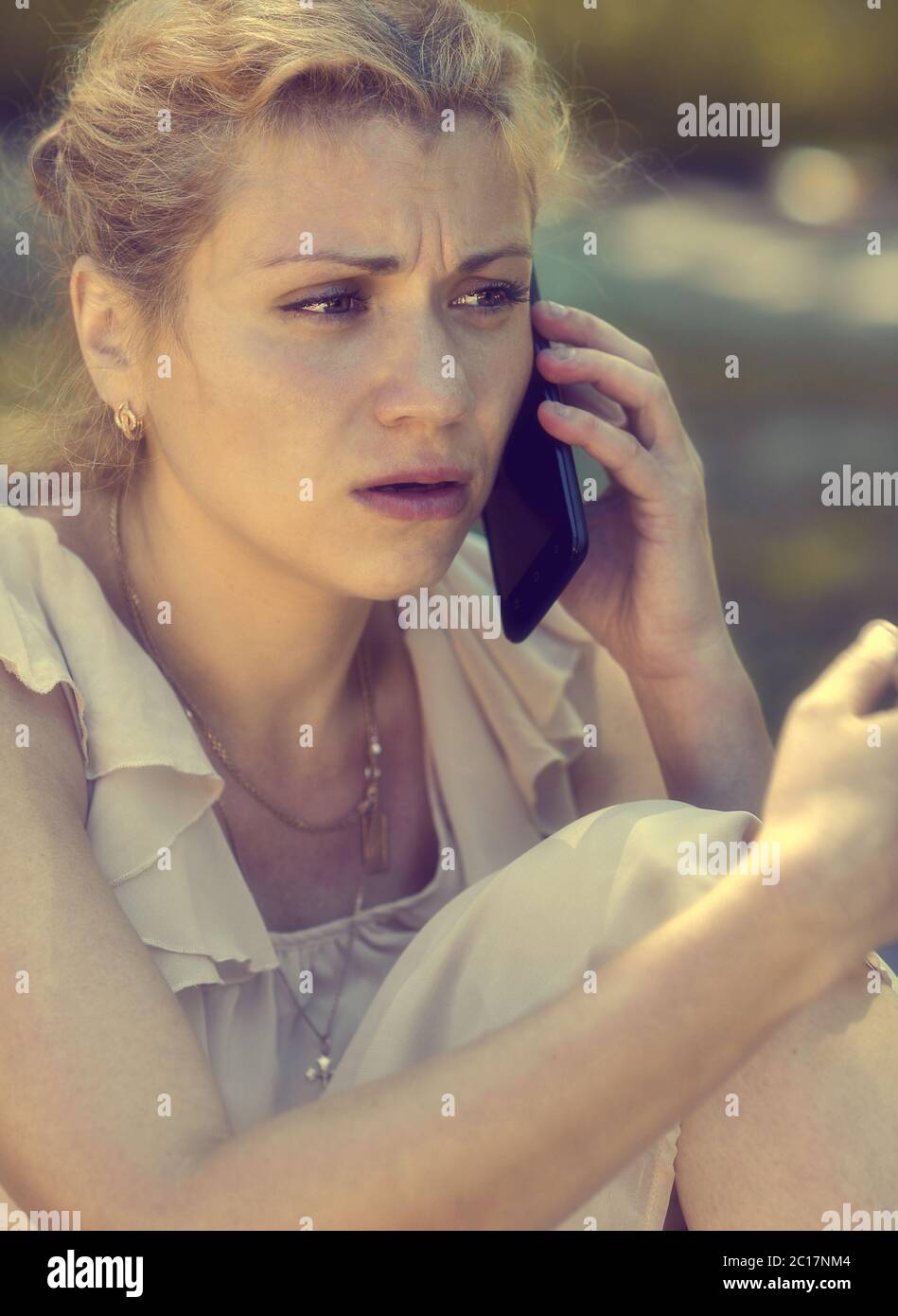 Girl talking on phone and being shocked Stock Photo