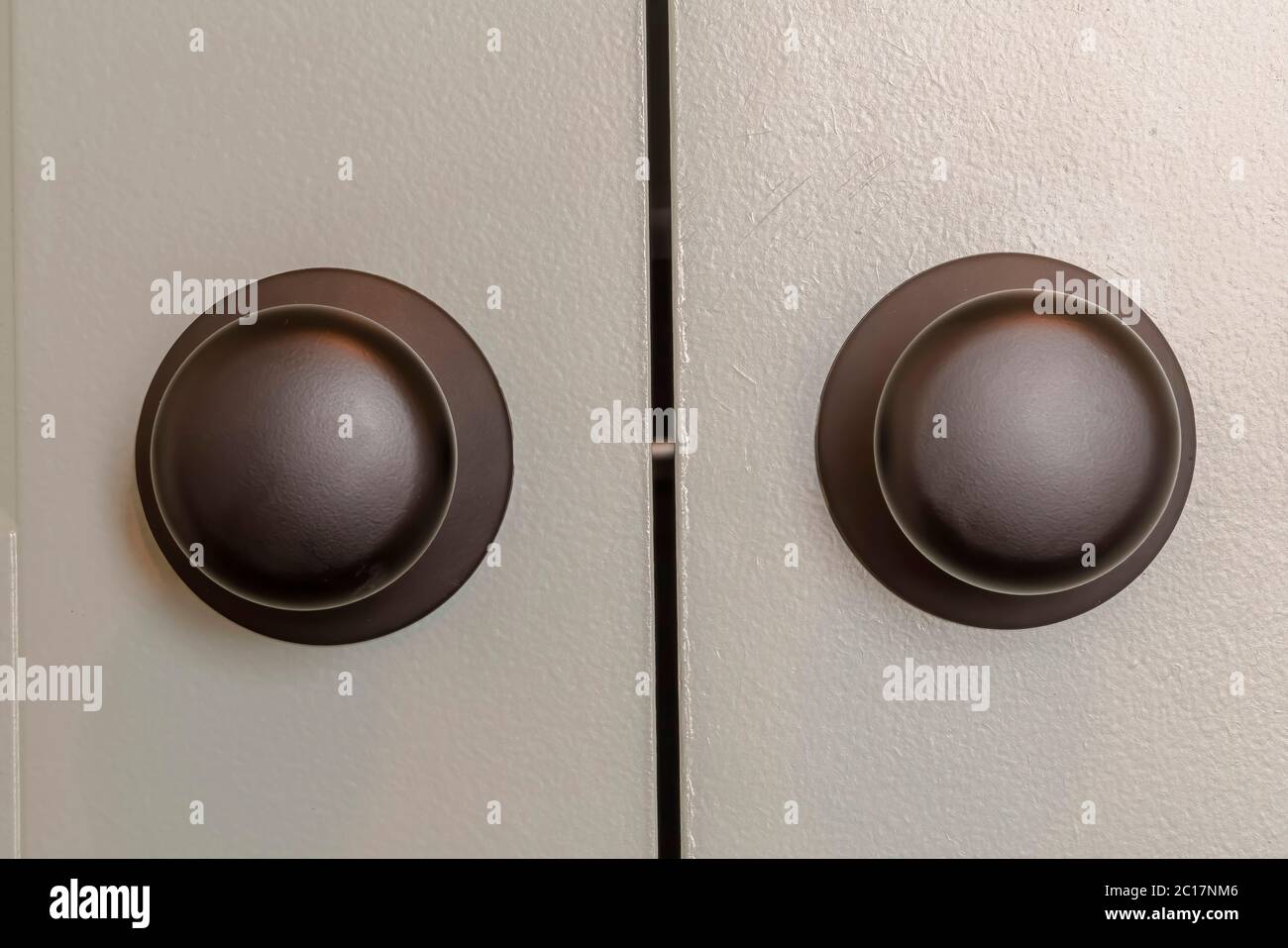 Close up view of matte black round door knobs of a gray bedroom double