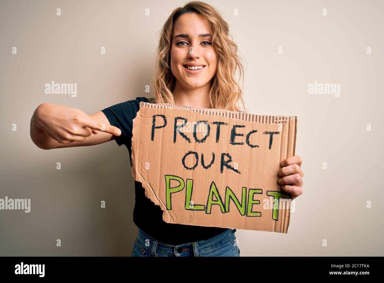 Young activist woman asking for environment holding banner with protect ...