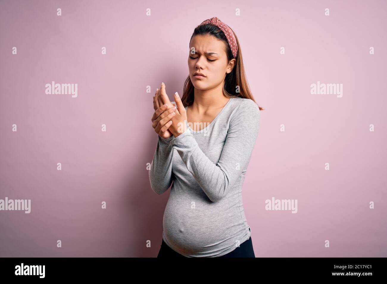 Young beautiful teenager girl pregnant expecting baby over isolated