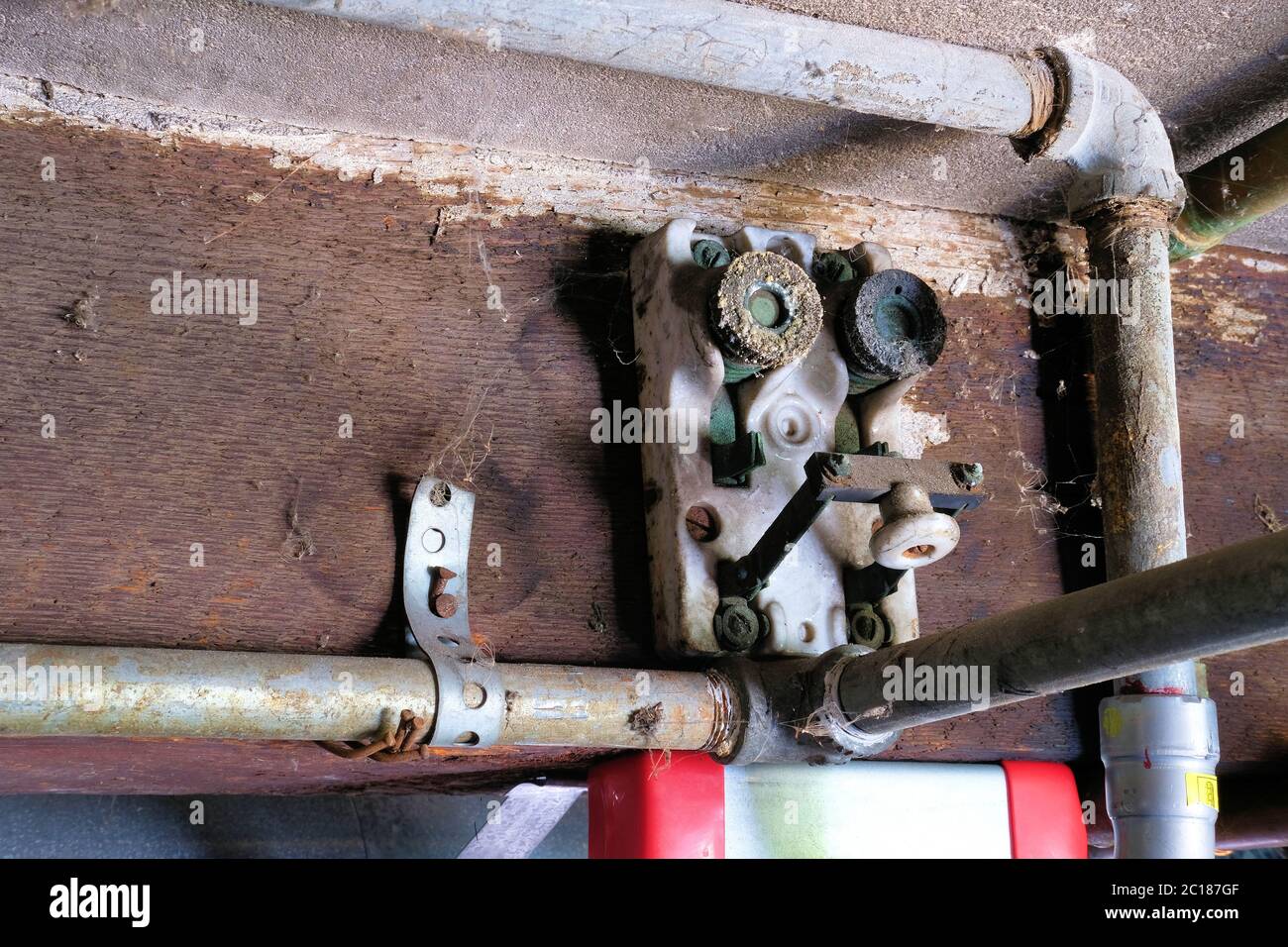 Antique porcelain block fuse switch circuit breaker; architectural breaker knife switches with mica fuse sockets screwed onto a wood beam. Stock Photo