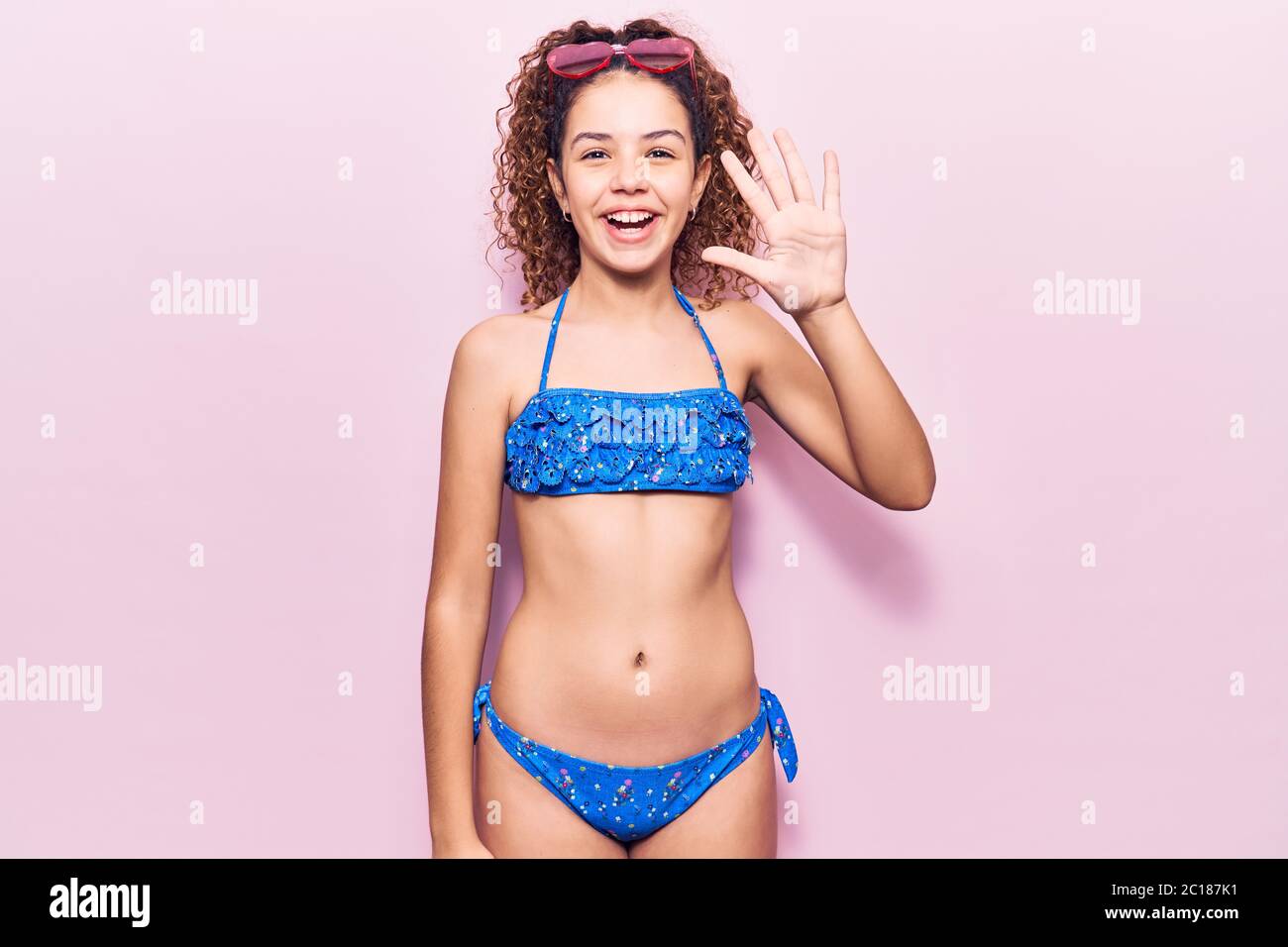 Beautiful kid girl with curly hair wearing bikini and sunglasses showing  and pointing up with fingers number five while smiling confident and happy  Stock Photo - Alamy