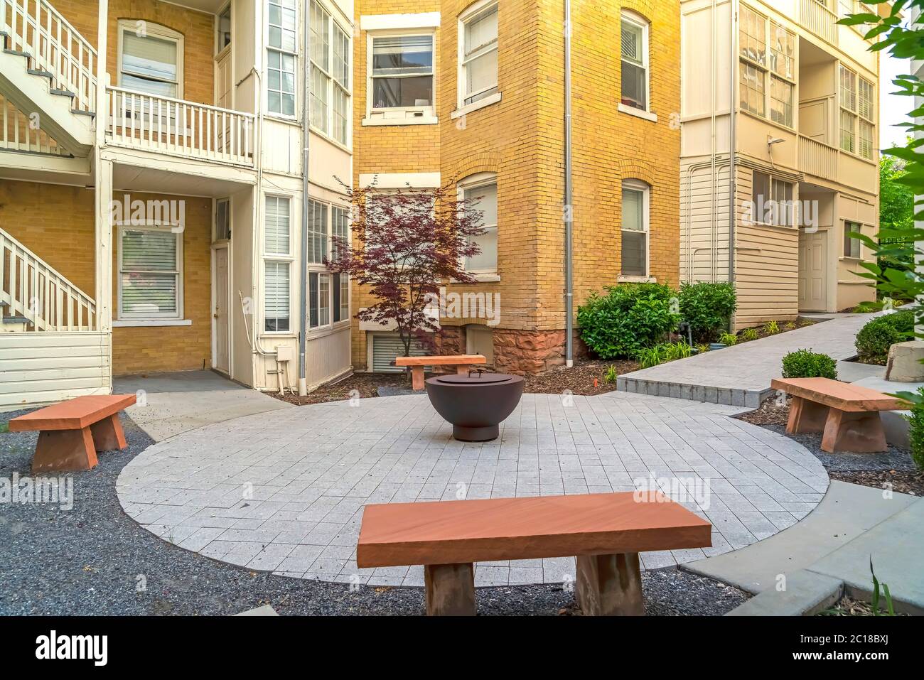 Stone benches around fire pit outside of a residential building complex