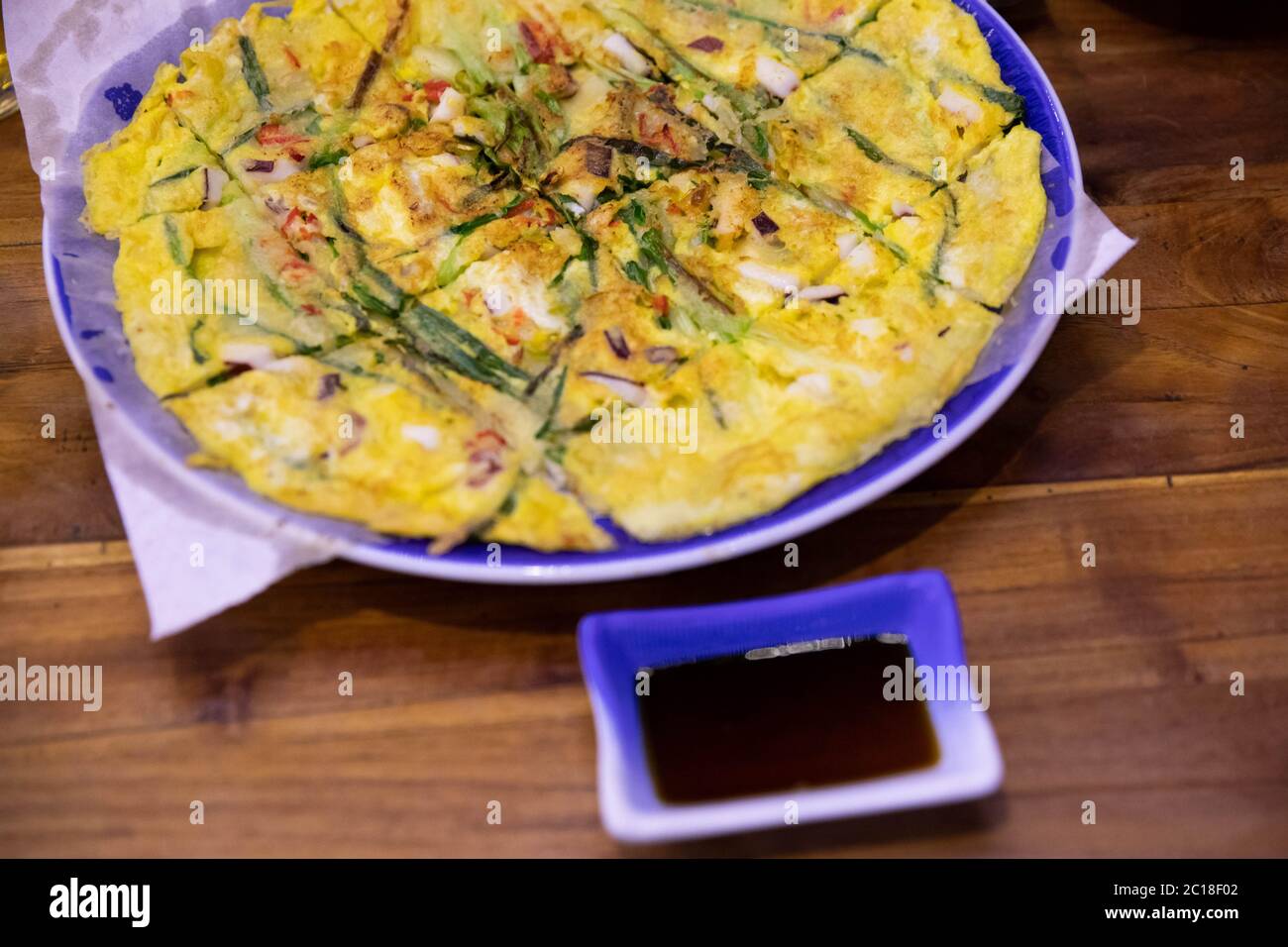 Korean savory seafood and scallions pancake on a big plate with dipping sauce. Stock Photo