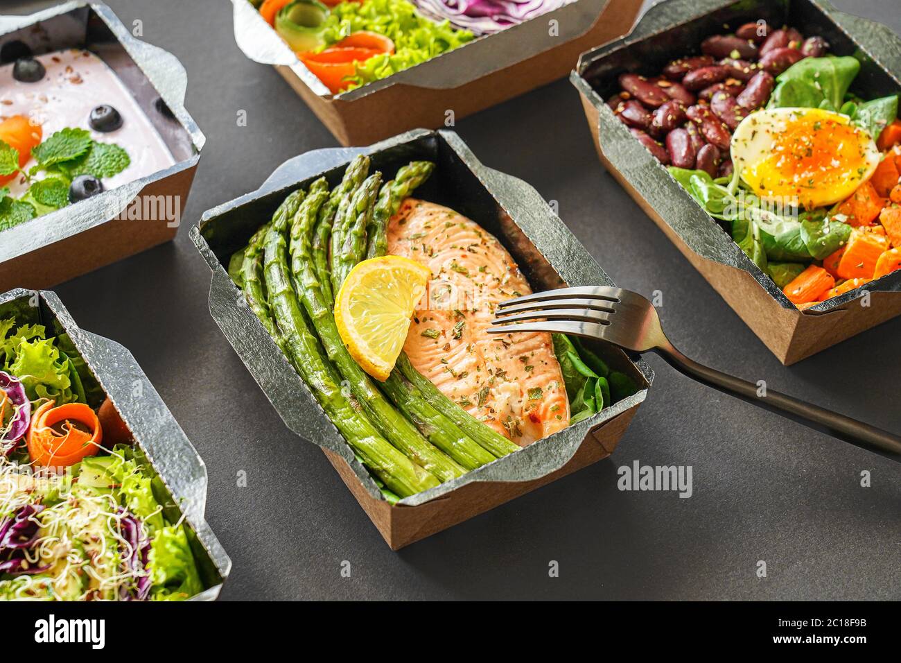 Ready healthy food menu meal delivery take away  boxes on black background. Stock Photo