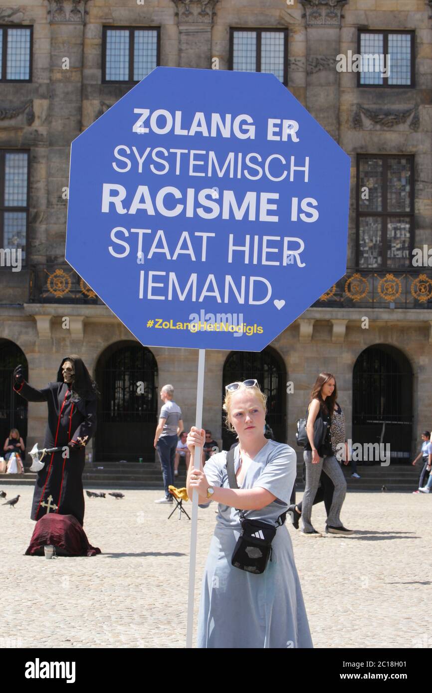 A protestor holds a placard with the sign ‘As long as systemic racism exists, someone will stand here’ during anti-racism action in front of the Royal Stock Photo