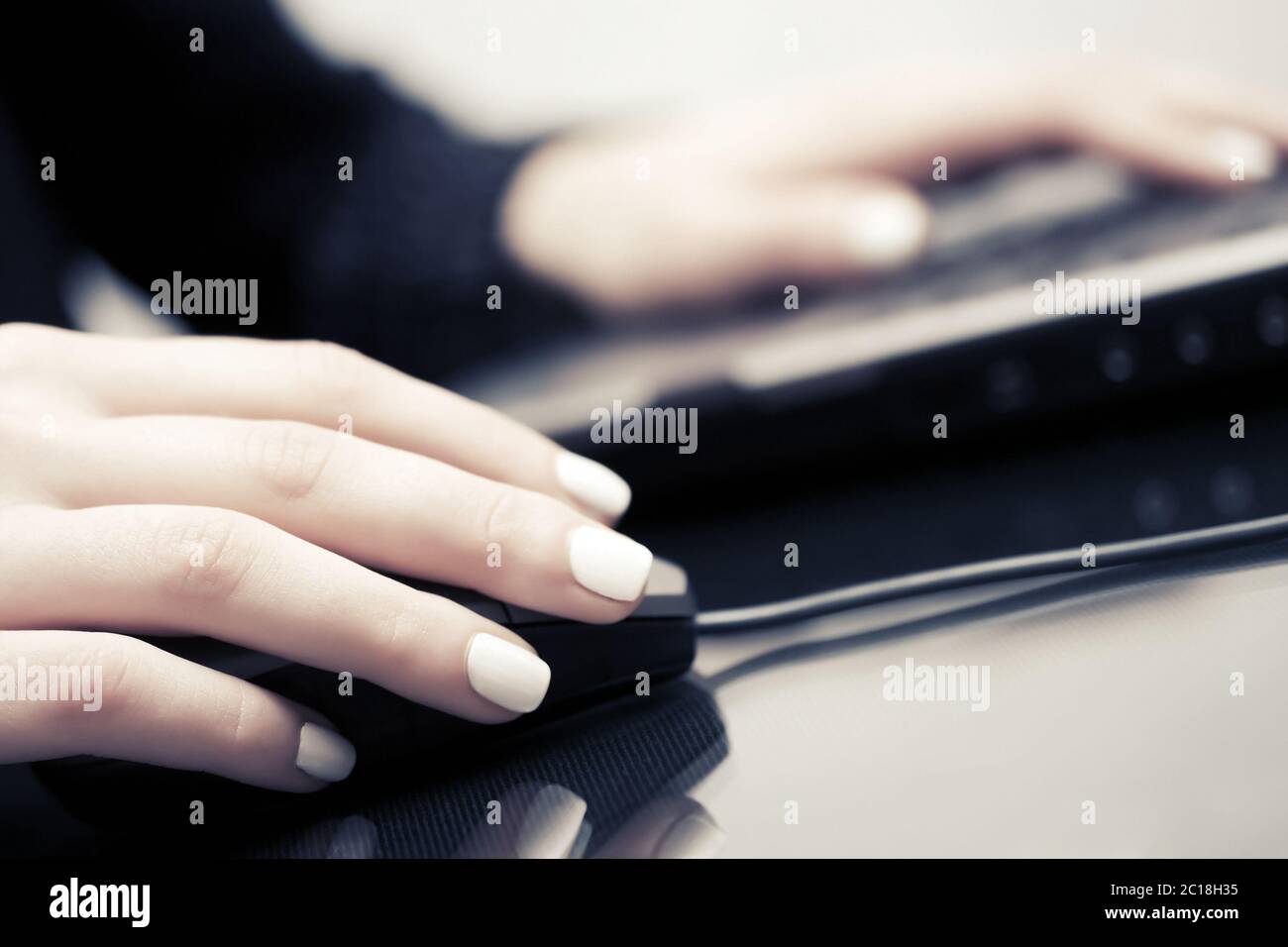 Woman using computer mouse and keyboard Stock Photo