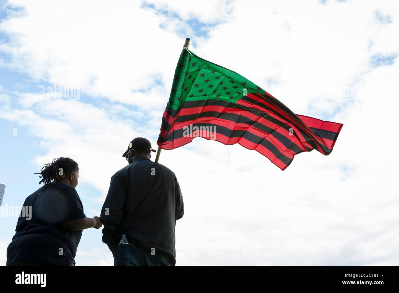A couple flies a Pan-African flag at a march in support of the Black Lives Matter movement in Seattle’s High Point neighborhood on Sunday, June 14, 2020. Stock Photo